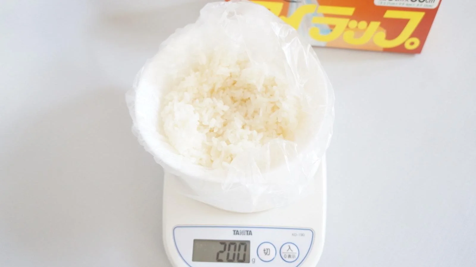 About 200 g of cooked rice in a plastic food bag on a kitchen scale