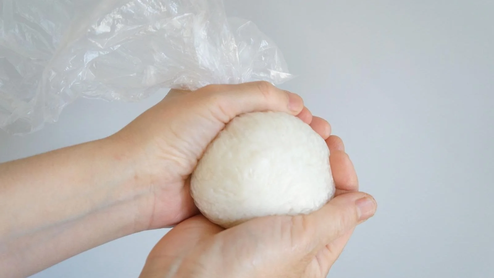 Two hands pressing the rice into a ball